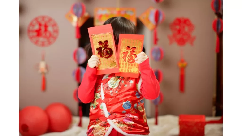 Em bé cầm phong bao lì xì đỏ.