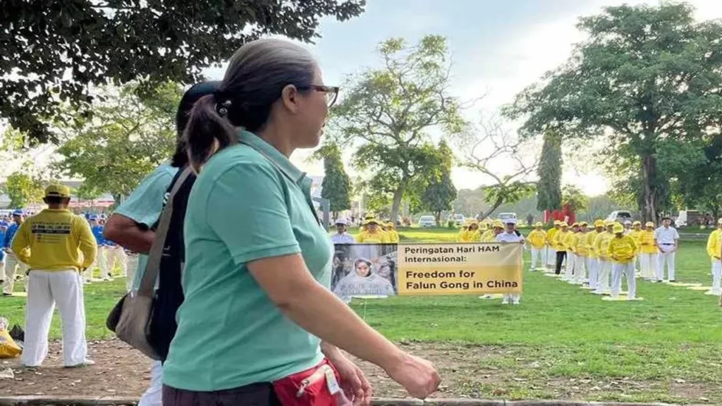 Nhiều người dừng lại và xem các học viên luyện các bài công pháp Pháp Luân Công.